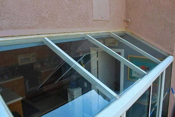 Clear glass panels reveal the interior of a conservatory.
