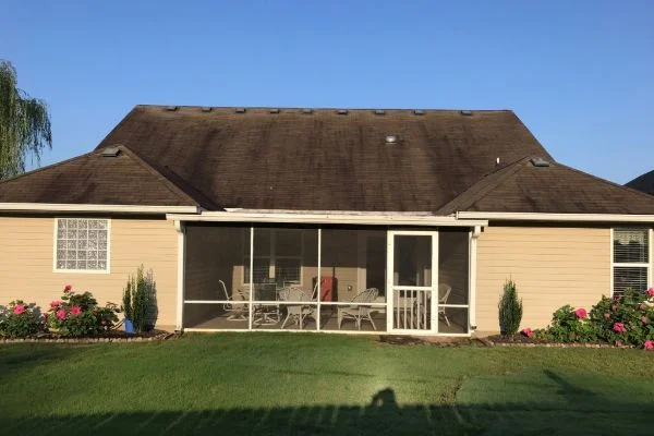 Dark streaks run across the roof above a screened porch.