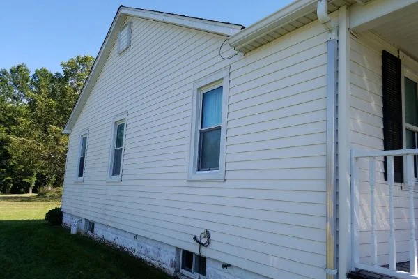White siding surrounds several windows along the side of a house.