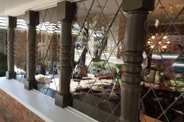 A decorative glass partition separates seating areas inside a building.